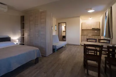 a bedroom with a bed and a table and a kitchen at Guest House Valentincic in Nova Gorica