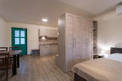 a bedroom with a bed and a table and a kitchen at Guest House Valentincic in Nova Gorica
