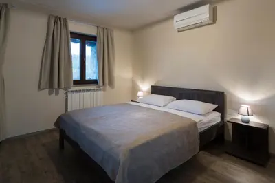 a bedroom with a bed with two pillows and a window at Guest House Valentincic in Nova Gorica
