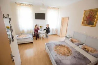 two women sitting at a table in a room at Hostel Sonce in Ptuj