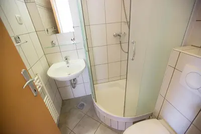 a bathroom with a shower and a toilet and a sink at Hostel Sonce in Ptuj