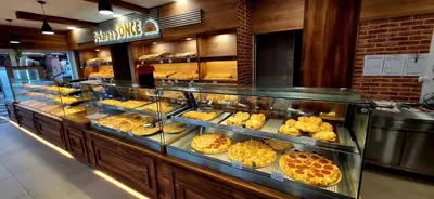 a bakery display case with many different types of pastries at Hostel Sonce in Ptuj