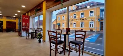 a restaurant with a table and chairs and a window at Hostel Sonce in Ptuj
