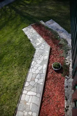 a garden with a stone walkway in the grass at Apartment Gaia in Lokve