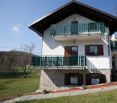 a house with a balcony on top of it at Apartment Gaia in Lokve