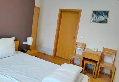 a bedroom with a bed and a table and chairs at Villa Mari I in Maribor