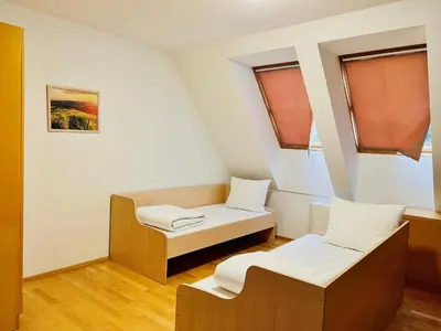 a small room with two beds and a window at Villa Mari I in Maribor
