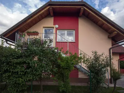 a red and white house with a balcony at Apartment Marjetka in Žirovnica
