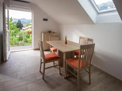 a dining room with a table and chairs and a window at Apartment Marjetka in Žirovnica