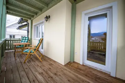 a porch with a table and a chair and a window at Apartments Vila Marjetica in Bled