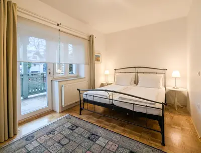 a bedroom with a bed and a large window at Apartments Vila Marjetica in Bled