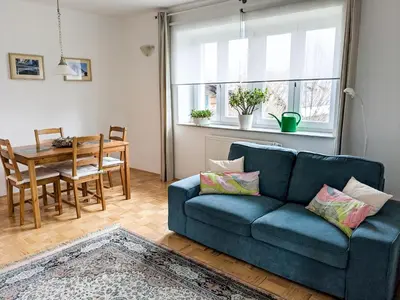 a living room with a blue couch and a table at Apartments Vila Marjetica in Bled