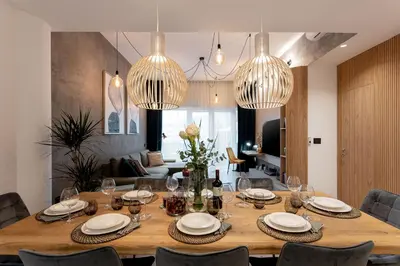 a dining room table with chairs and chandeliers at Apartment Zoja in Kranjska Gora