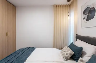 a bedroom with a bed with white sheets and pillows at Apartment Zoja in Kranjska Gora
