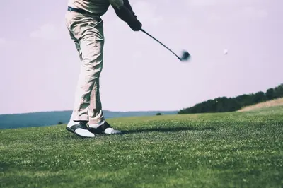 a woman is playing golf on a golf course at Mokrice Castle Estate in Čatež ob Savi