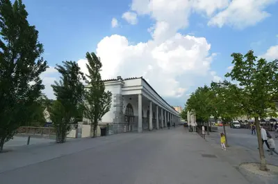 a large white building on a street with trees at RIVER SIDE CENTRAL MARKET - Eclipse superior apartment in Ljubljana