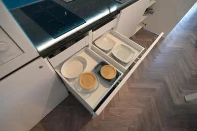 an open drawer in a kitchen with plates and bowls at RIVER SIDE CENTRAL MARKET - Eclipse superior apartment in Ljubljana