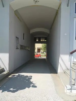 an empty hallway of a building with a car outside at Apartma MB-Center in Maribor