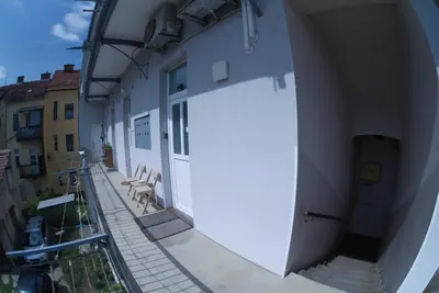 an alley with a white wall and two chairs at Apartma MB-Center in Maribor