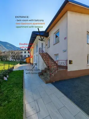 a house with a stairway in front of it at Apartment and room Anica in Tolmin