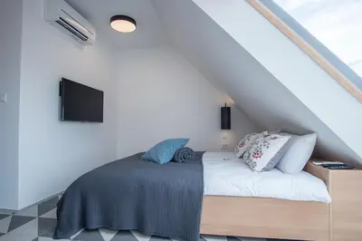 a bedroom with a bed with a tv on the wall at Stella Sky in Ljubljana