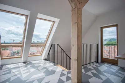 a room with large windows and a staircase with checkered floor at Stella Sky in Ljubljana