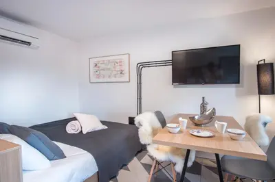 a room with a bed and a table and a tv at Stella Sky in Ljubljana