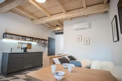 a living room with a table and a kitchen at Stella Sky in Ljubljana