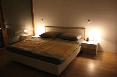 a bedroom with a large bed with two lamps at Guest accomodation Klancar in Ig