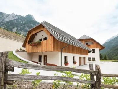 a house in the mountains with a fence at House DorMica in Trenta