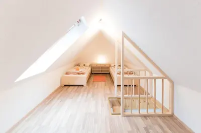 a loft bedroom with a bed and a ladder at House DorMica in Trenta