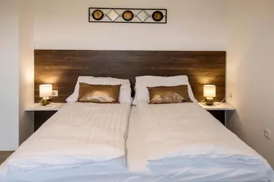 a bedroom with a large bed with two lamps at Apartments Vila Apolonia in Ljubljana