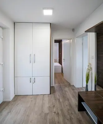 a living room with white cabinets and wood floors at Apartments Vila Apolonia in Ljubljana