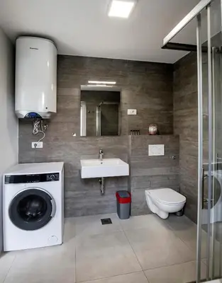 a bathroom with a washing machine and a sink at Apartments Vila Apolonia in Ljubljana