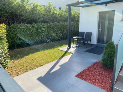 a patio with a table and chairs in a yard at Apartments Vila Apolonia in Ljubljana