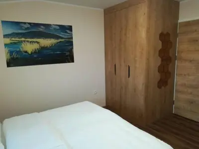 a bedroom with a bed and a wooden cabinet at GOSTILNA S PRENOČIŠČI PAV in Rakek