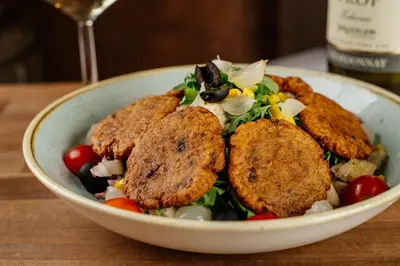 a bowl of food with chicken and a salad at GLUTEN FREE Bed & Breakfast Dežela Okusov in Ljubljana