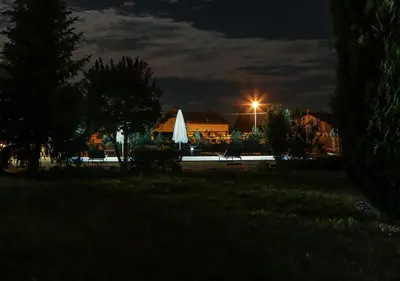 a lit up umbrella in a park at night at Vila Izabela in Križevci pri Ljutomeru