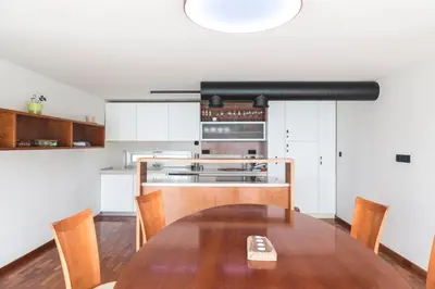 a kitchen with a wooden table and a kitchen with white cabinets at Vila Izabela in Križevci pri Ljutomeru