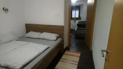 a small bedroom with a bed and a hallway at Apartment Slavija in Škofja Loka
