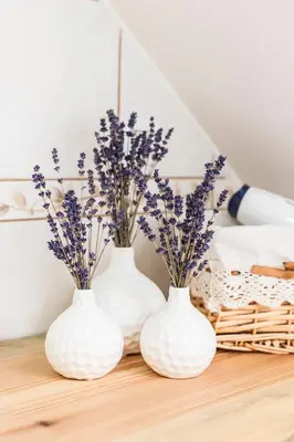 three white vases with flowers in them on a table at Terasse Jeruzalem Apartments in Hermanci