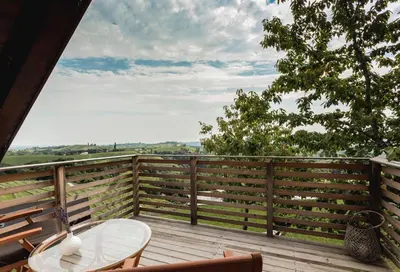 a wooden deck with a table and a chair at Terasse Jeruzalem Apartments in Hermanci
