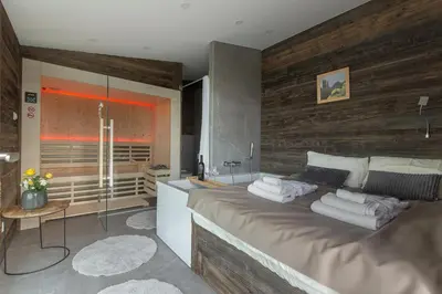 a bedroom with a large bed and a bathroom at Terasse Jeruzalem Apartments in Hermanci