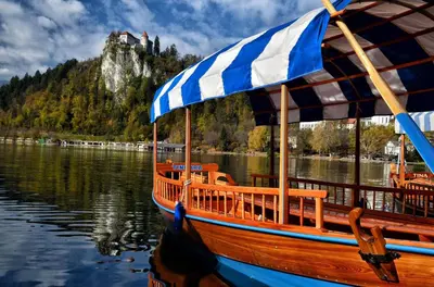 a wooden boat with an umbrella on the water at 238 Spodnje Gorje in Spodnje Gorje