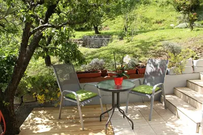 two chairs and a table on a patio with a tree at 238 Spodnje Gorje in Spodnje Gorje