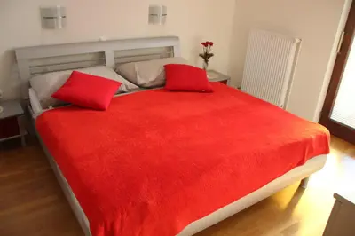 a large red bed with two red pillows on it at 238 Spodnje Gorje in Spodnje Gorje
