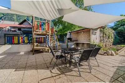 a patio with a table and chairs under an umbrella at Penzion Hosnar, apartma Time Out in Bovec
