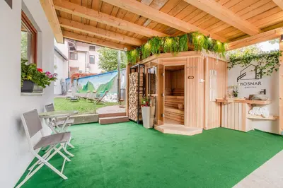 a patio with a green floor and a table and chair at Penzion Hosnar, apartma Time Out in Bovec