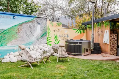 a patio with two chairs and a grill and a waterfall at Penzion Hosnar, apartma Time Out in Bovec