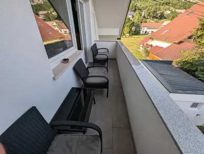 a balcony with three chairs and a window at Apartment Bee near Bled in Zabreznica
